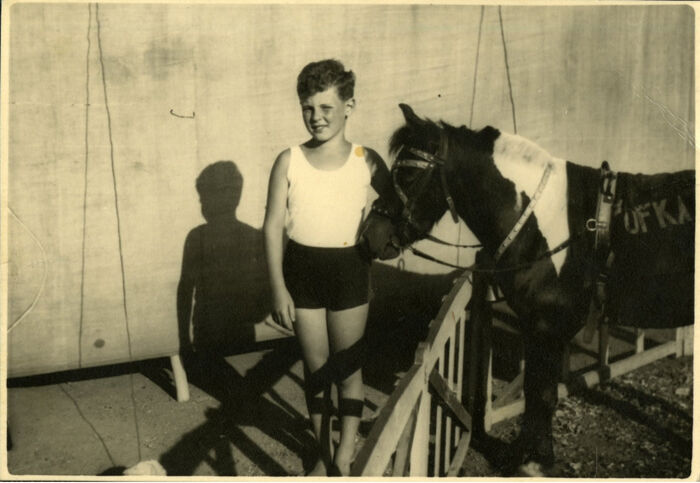 Liten gutt i shorts og t-skjorte ved siden av en ponny. Sort-hvitt bilde
